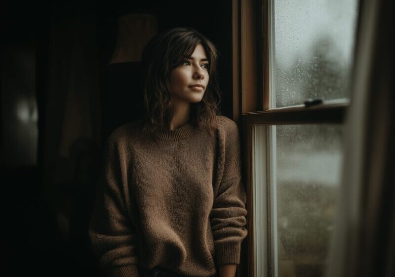 Alleen starend uit het raam